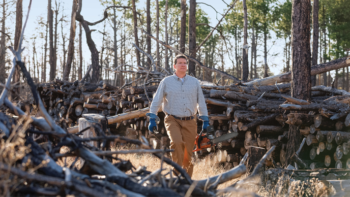 Neil Behnke, winner of the Small Machines. Big Impact. contest, walks through remains of the Black Forest in Colorado. 